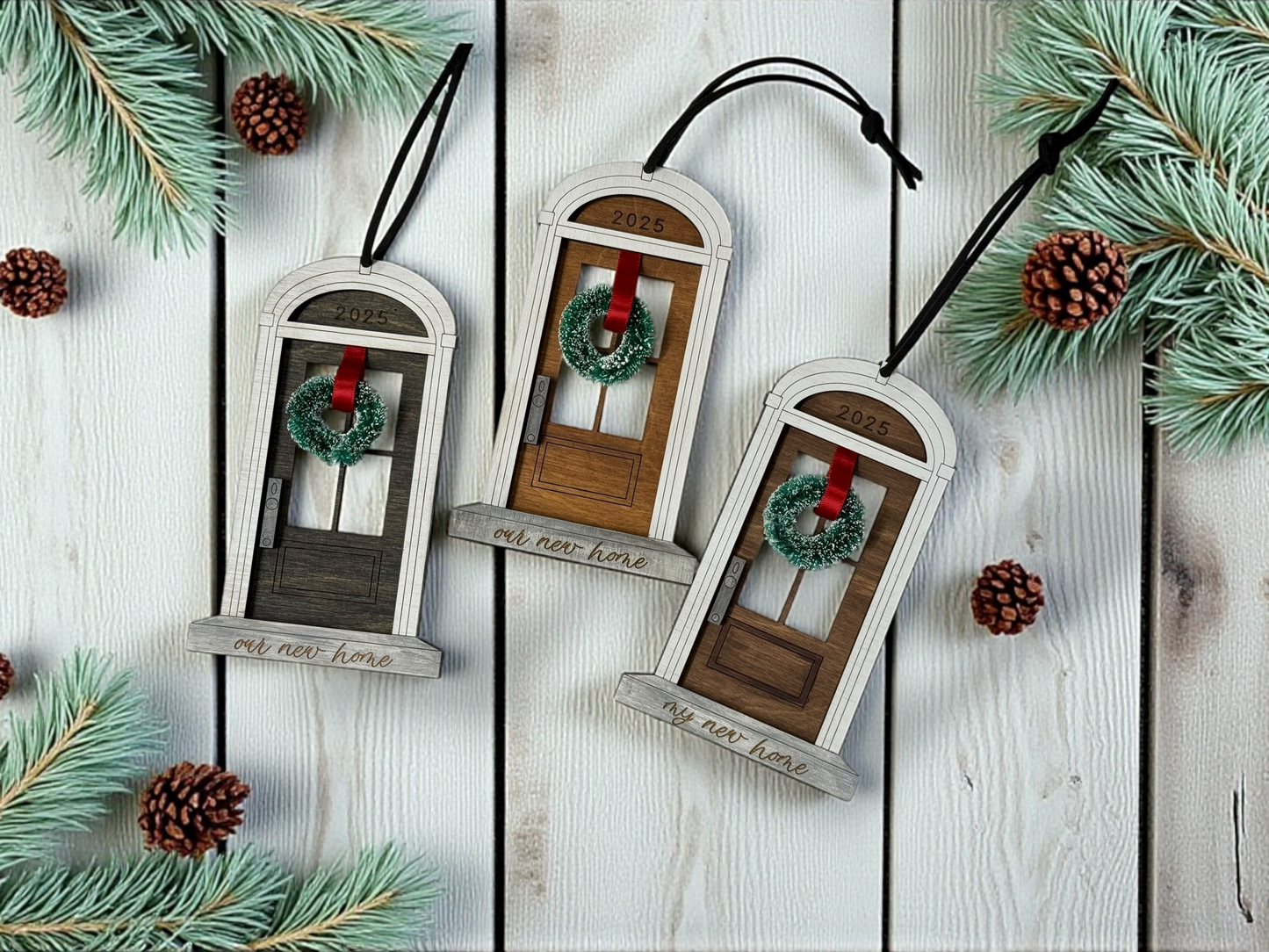 Decorative front foor -shaped ornaments with wreaths on a wooden surface with pine branches.