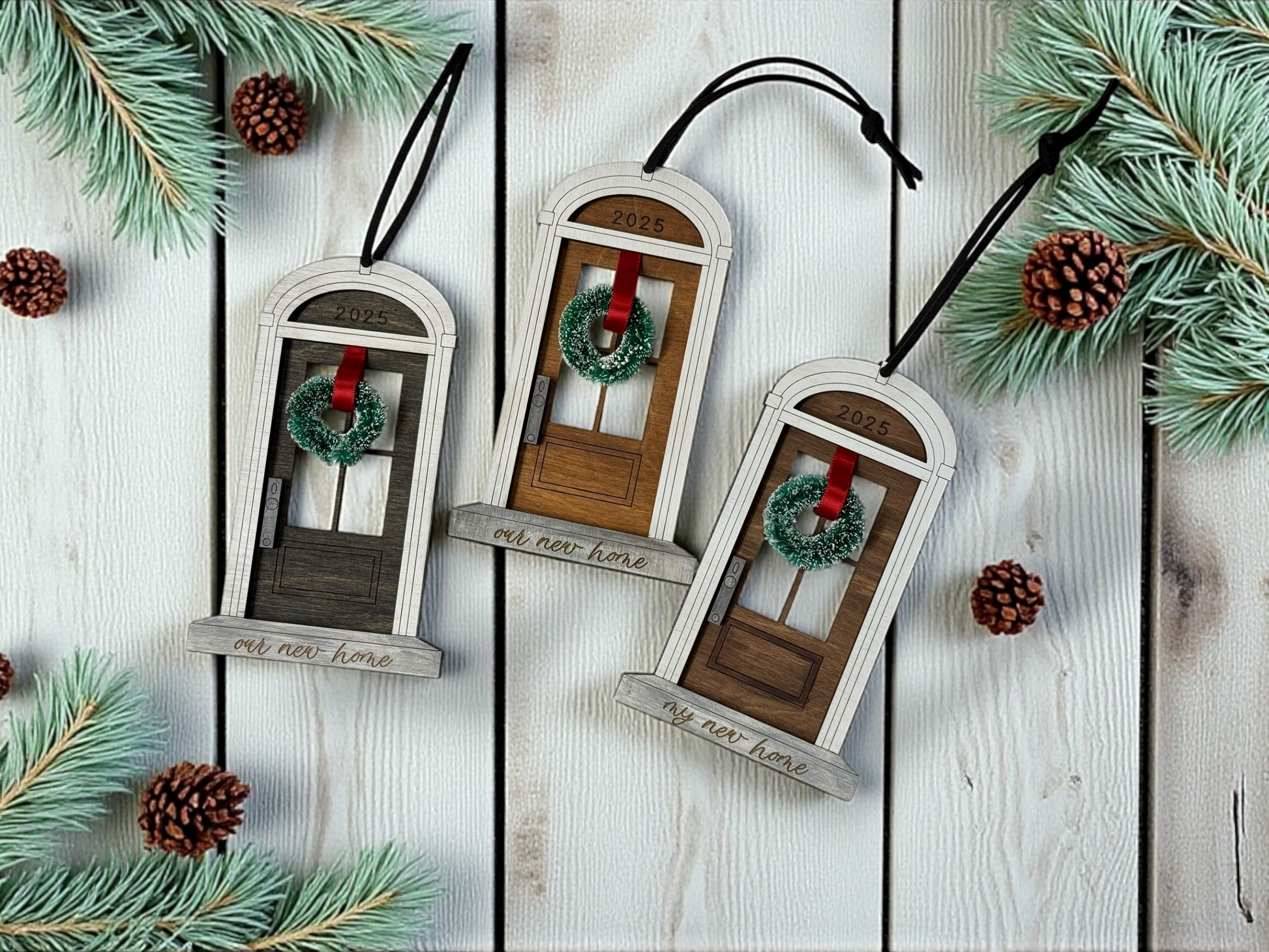 Decorative front foor -shaped ornaments with wreaths on a wooden surface with pine branches.