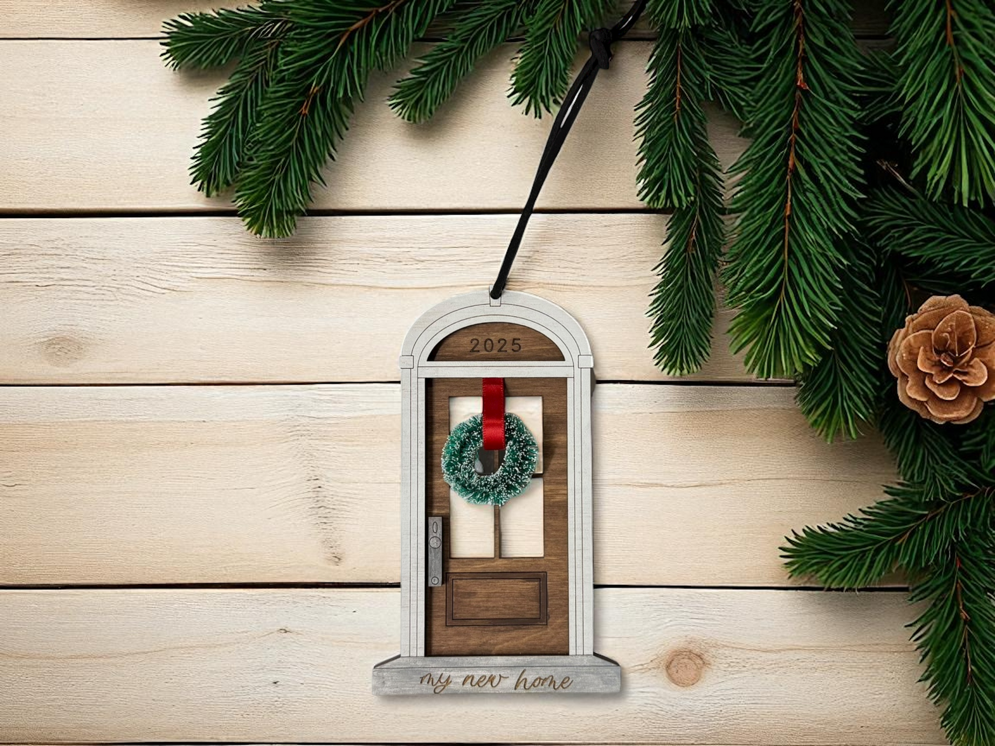 Decorative door ornament with wreath on a wooden surface with Christmas decorations.