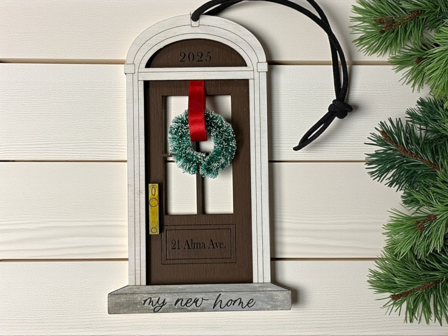 Decorative door ornament with a wreath and red ribbon on a wooden background